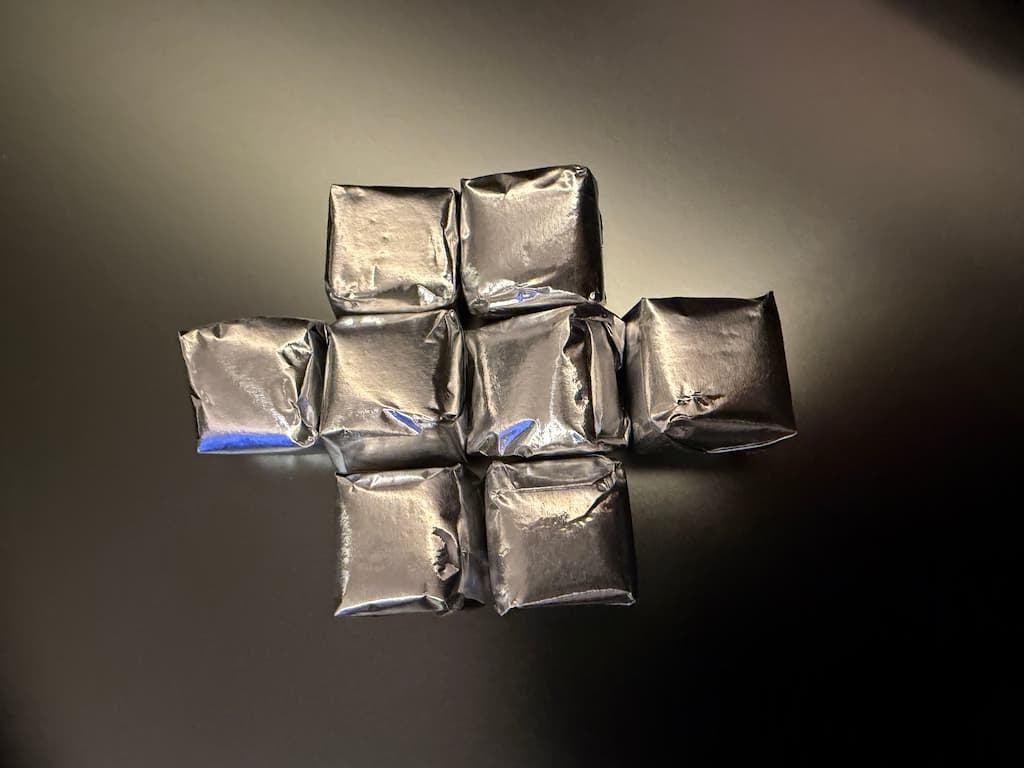 Silver packages arranged in a cross shape on a dark background